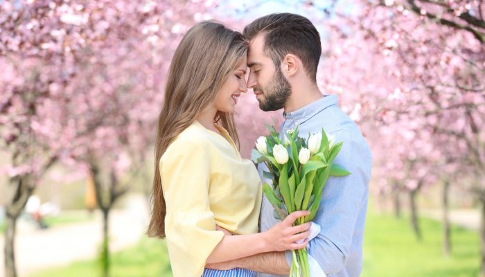 Young lovely couple walking in spring park