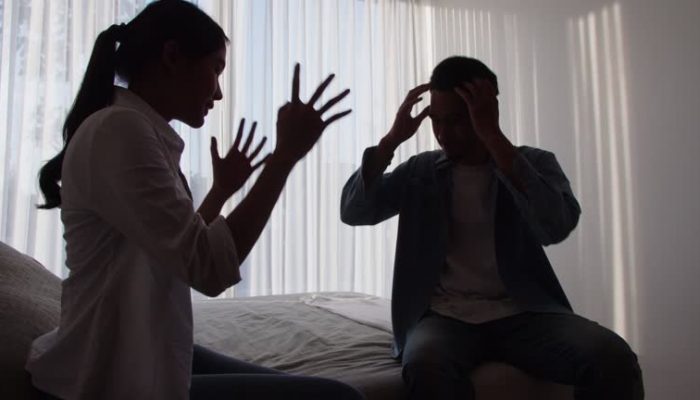 Silhouette 4k resolution footage of young Asian couple having an argument in bedroom at home, shouting and blaming each other of problems. Man and woman fighting during a conflict. Relationship problems