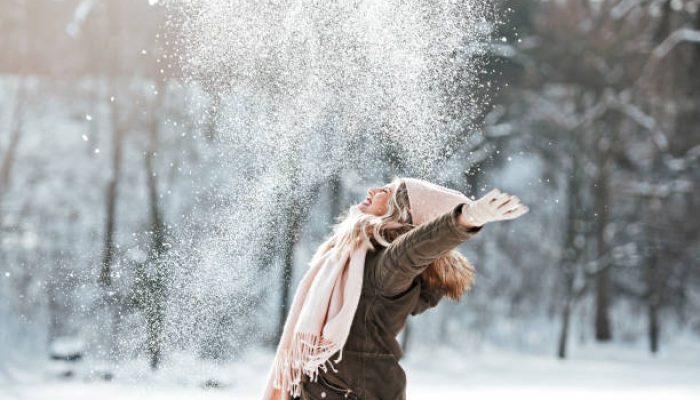 Beautiful young woman enjoying in the snow