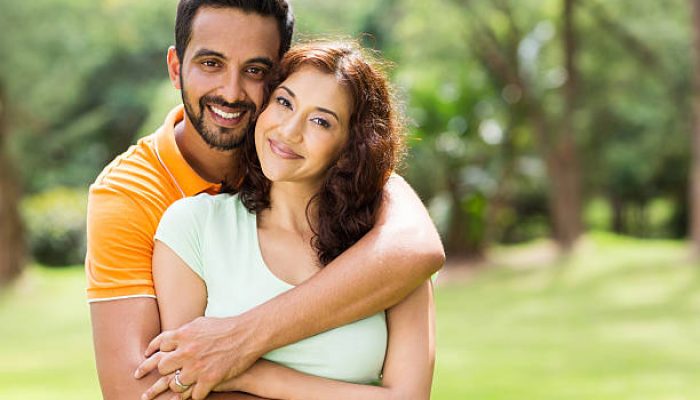 lovely young indian couple hugging outdoors