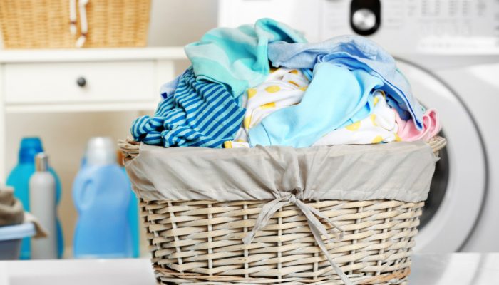 mixed-coloured-clothes-in-a-basket-in-front-of-a-tumble-dryer