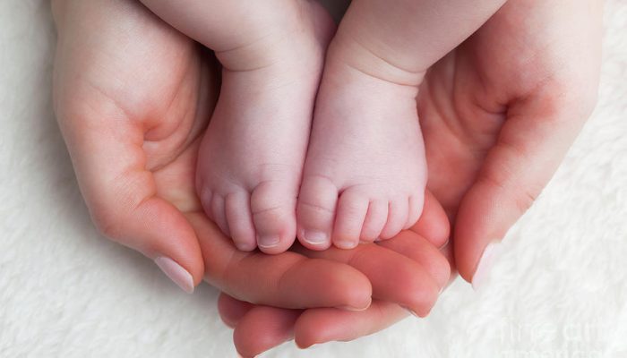 newborn-baby-feet-in-mothers-hands-child-care-feeling-safe-protect-michal-bednarek