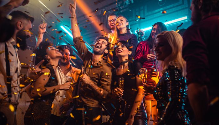 Group of energetic young people dancing at a party in a nightclub